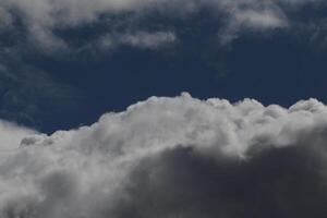 Cloudscape escenario, nublado clima encima oscuro azul cielo. tormenta nubes flotante en un lluvioso aburrido día con natural ligero. blanco y gris escénico ambiente antecedentes. naturaleza vista. foto