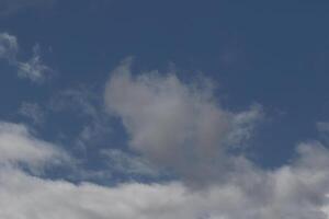 Cloudscape scenery, overcast weather above dark blue sky. Storm clouds floating in a rainy dull day with natural light. White and grey scenic environment background. Nature view. photo