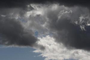 Cloudscape scenery, overcast weather above dark blue sky. Storm clouds floating in a rainy dull day with natural light. White and grey scenic environment background. Nature view. photo