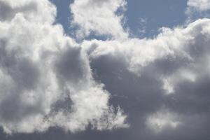 Cloudscape scenery, overcast weather above dark blue sky. Storm clouds floating in a rainy dull day with natural light. White and grey scenic environment background. Nature view. photo