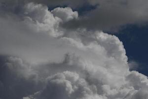 Cloudscape scenery, overcast weather above dark blue sky. Storm clouds floating in a rainy dull day with natural light. White and grey scenic environment background. Nature view. photo