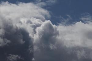 Cloudscape scenery, overcast weather above dark blue sky. Storm clouds floating in a rainy dull day with natural light. White and grey scenic environment background. Nature view. photo