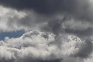 Cloudscape scenery, overcast weather above dark blue sky. Storm clouds floating in a rainy dull day with natural light. White and grey scenic environment background. Nature view. photo