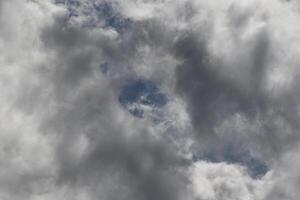 Cloudscape scenery, overcast weather above dark blue sky. Storm clouds floating in a rainy dull day with natural light. White and grey scenic environment background. Nature view. photo