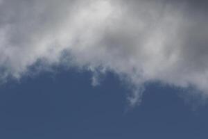 Cloudscape scenery, overcast weather above dark blue sky. Storm clouds floating in a rainy dull day with natural light. White and grey scenic environment background. Nature view. photo
