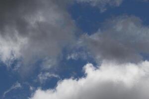 Cloudscape scenery, overcast weather above dark blue sky. Storm clouds floating in a rainy dull day with natural light. White and grey scenic environment background. Nature view. photo