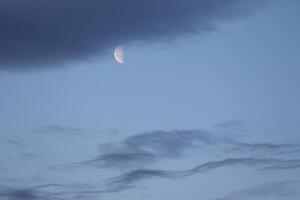 el vistoso azul suave cielo encima el nubes con medio Luna foto