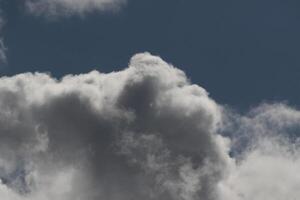 Cloudscape scenery, overcast weather above dark blue sky. Storm clouds floating in a rainy dull day with natural light. White and grey scenic environment background. Nature view. photo