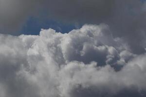 Cloudscape scenery, overcast weather above dark blue sky. Storm clouds floating in a rainy dull day with natural light. White and grey scenic environment background. Nature view. photo