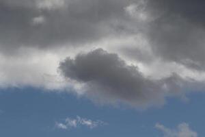 Cloudscape scenery, overcast weather above dark blue sky. Storm clouds floating in a rainy dull day with natural light. White and grey scenic environment background. Nature view. photo