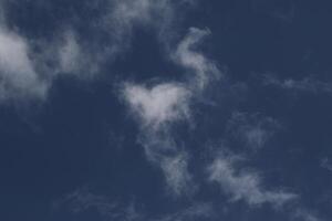 Cloudscape scenery, overcast weather above dark blue sky. Storm clouds floating in a rainy dull day with natural light. White and grey scenic environment background. Nature view. photo