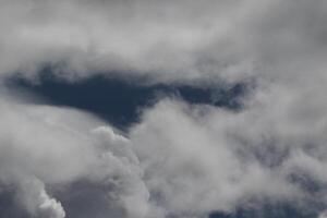 Cloudscape escenario, nublado clima encima oscuro azul cielo. tormenta nubes flotante en un lluvioso aburrido día con natural ligero. blanco y gris escénico ambiente antecedentes. naturaleza vista. foto