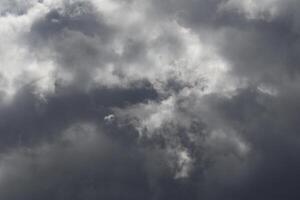 Cloudscape scenery, overcast weather above dark blue sky. Storm clouds floating in a rainy dull day with natural light. White and grey scenic environment background. Nature view. photo
