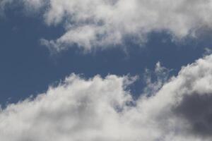 Cloudscape scenery, overcast weather above dark blue sky. Storm clouds floating in a rainy dull day with natural light. White and grey scenic environment background. Nature view. photo