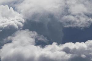 Cloudscape scenery, overcast weather above dark blue sky. Storm clouds floating in a rainy dull day with natural light. White and grey scenic environment background. Nature view. photo
