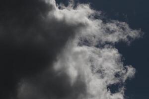 Cloudscape scenery, overcast weather above dark blue sky. Storm clouds floating in a rainy dull day with natural light. White and grey scenic environment background. Nature view. photo