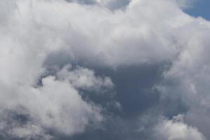 Cloudscape scenery, overcast weather above dark blue sky. Storm clouds floating in a rainy dull day with natural light. White and grey scenic environment background. Nature view. photo