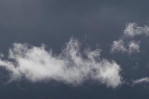 Cloudscape scenery, overcast weather above dark blue sky. Storm clouds floating in a rainy dull day with natural light. White and grey scenic environment background. Nature view. photo