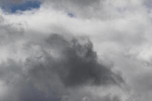 Cloudscape scenery, overcast weather above dark blue sky. Storm clouds floating in a rainy dull day with natural light. White and grey scenic environment background. Nature view. photo