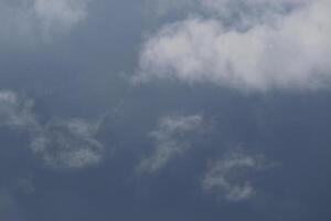 Cloudscape scenery, overcast weather above dark blue sky. Storm clouds floating in a rainy dull day with natural light. White and grey scenic environment background. Nature view. photo