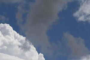 Cloudscape scenery, overcast weather above dark blue sky. Storm clouds floating in a rainy dull day with natural light. White and grey scenic environment background. Nature view. photo