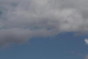 Cloudscape scenery, overcast weather above dark blue sky. Storm clouds floating in a rainy dull day with natural light. White and grey scenic environment background. Nature view. photo