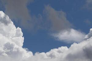 Cloudscape scenery, overcast weather above dark blue sky. Storm clouds floating in a rainy dull day with natural light. White and grey scenic environment background. Nature view. photo
