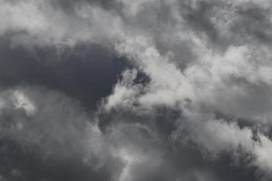 Cloudscape scenery, overcast weather above dark blue sky. Storm clouds floating in a rainy dull day with natural light. White and grey scenic environment background. Nature view. photo