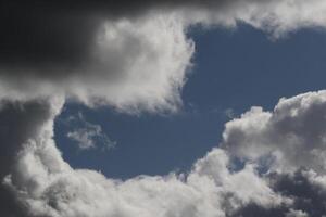 Cloudscape scenery, overcast weather above dark blue sky. Storm clouds floating in a rainy dull day with natural light. White and grey scenic environment background. Nature view. photo