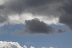 Cloudscape scenery, overcast weather above dark blue sky. Storm clouds floating in a rainy dull day with natural light. White and grey scenic environment background. Nature view. photo