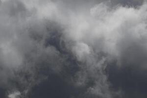 Cloudscape scenery, overcast weather above dark blue sky. Storm clouds floating in a rainy dull day with natural light. White and grey scenic environment background. Nature view. photo