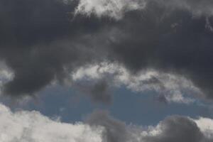 Cloudscape scenery, overcast weather above dark blue sky. Storm clouds floating in a rainy dull day with natural light. White and grey scenic environment background. Nature view. photo