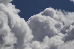 Cloudscape scenery, overcast weather above dark blue sky. Storm clouds floating in a rainy dull day with natural light. White and grey scenic environment background. Nature view. photo