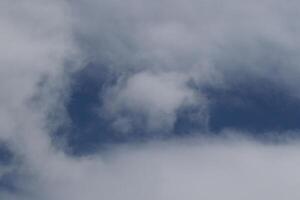 Cloudscape escenario, nublado clima encima oscuro azul cielo. tormenta nubes flotante en un lluvioso aburrido día con natural ligero. blanco y gris escénico ambiente antecedentes. naturaleza vista. foto