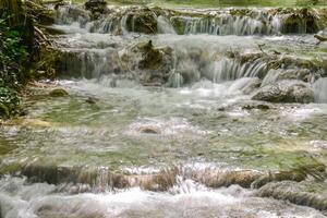 Mountain stream in the forest - long exposure and flowing water photo