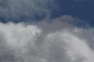 Cloudscape scenery, overcast weather above dark blue sky. Storm clouds floating in a rainy dull day with natural light. White and grey scenic environment background. Nature view. photo