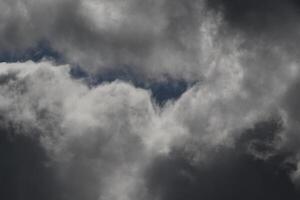 Cloudscape escenario, nublado clima encima oscuro azul cielo. tormenta nubes flotante en un lluvioso aburrido día con natural ligero. blanco y gris escénico ambiente antecedentes. naturaleza vista. foto