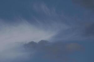 Cloudscape scenery, overcast weather above dark blue sky. Storm clouds floating in a rainy dull day with natural light. White and grey scenic environment background. Nature view. photo