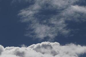 Cloudscape scenery, overcast weather above dark blue sky. Storm clouds floating in a rainy dull day with natural light. White and grey scenic environment background. Nature view. photo