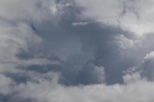 Cloudscape scenery, overcast weather above dark blue sky. Storm clouds floating in a rainy dull day with natural light. White and grey scenic environment background. Nature view. photo