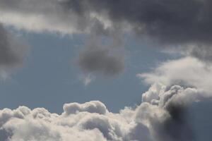 Cloudscape scenery, overcast weather above dark blue sky. Storm clouds floating in a rainy dull day with natural light. White and grey scenic environment background. Nature view. photo