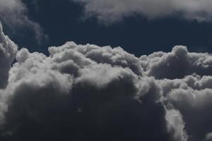 Cloudscape scenery, overcast weather above dark blue sky. Storm clouds floating in a rainy dull day with natural light. White and grey scenic environment background. Nature view. photo