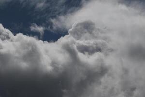 Cloudscape scenery, overcast weather above dark blue sky. Storm clouds floating in a rainy dull day with natural light. White and grey scenic environment background. Nature view. photo