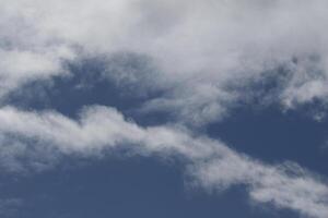 Cloudscape scenery, overcast weather above dark blue sky. Storm clouds floating in a rainy dull day with natural light. White and grey scenic environment background. Nature view. photo