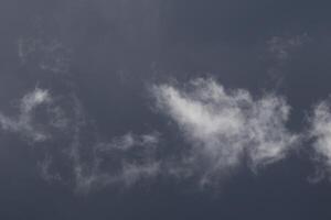 Cloudscape scenery, overcast weather above dark blue sky. Storm clouds floating in a rainy dull day with natural light. White and grey scenic environment background. Nature view. photo