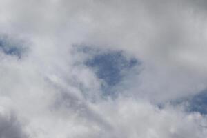 Cloudscape scenery, overcast weather above dark blue sky. Storm clouds floating in a rainy dull day with natural light. White and grey scenic environment background. Nature view. photo