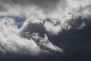 Cloudscape scenery, overcast weather above dark blue sky. Storm clouds floating in a rainy dull day with natural light. White and grey scenic environment background. Nature view. photo