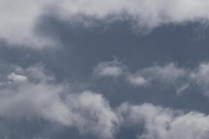 Cloudscape scenery, overcast weather above dark blue sky. Storm clouds floating in a rainy dull day with natural light. White and grey scenic environment background. Nature view. photo