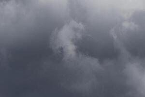 Cloudscape scenery, overcast weather above dark blue sky. Storm clouds floating in a rainy dull day with natural light. White and grey scenic environment background. Nature view. photo