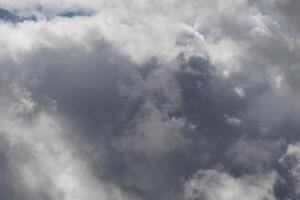 Cloudscape scenery, overcast weather above dark blue sky. Storm clouds floating in a rainy dull day with natural light. White and grey scenic environment background. Nature view. photo